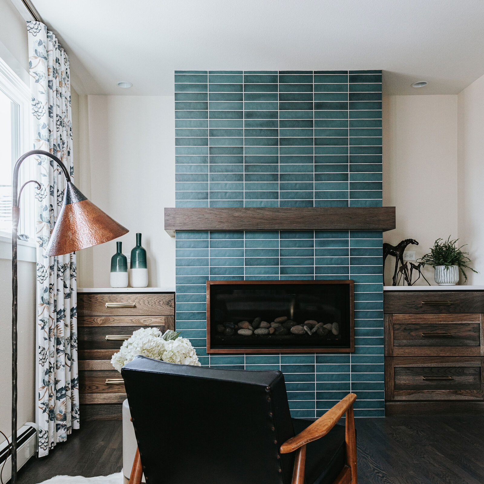 Teal tiled fireplace with built-in cabinetry